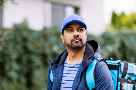 indian delivery man with bag in cityの写真素材