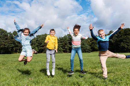 happy children jumping and having fun at parkの写真素材