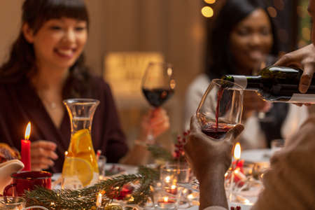 happy friends drinking wine at christmas partyの写真素材