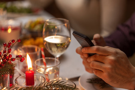hands with smartphone at christmas dinner partyの写真素材