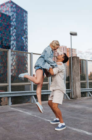 happy young couple on roof top city parkingの写真素材