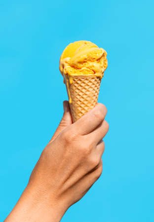 close up of hand holding waffle ice cream cone