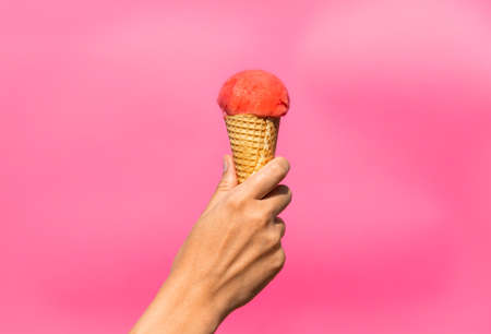 close up of hand holding waffle ice cream coneの写真素材