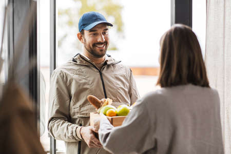 food delivery man giving order to female customerの写真素材