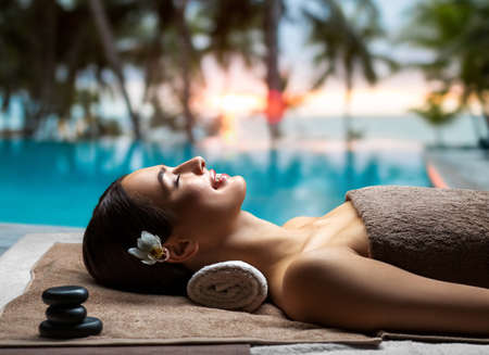 young woman lying at spa or massage parlorの写真素材