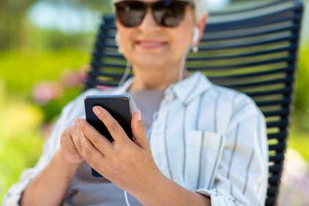 close up of woman with earphones and smartphone