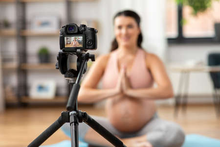 pregnant woman or yoga blogger with camera at homeの写真素材