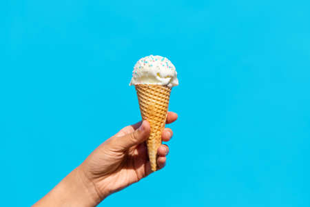 close up of hand holding waffle ice cream cone