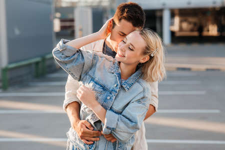 happy young couple hugging on city parkingの写真素材