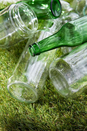 close up of empty glass bottles and jars on grass