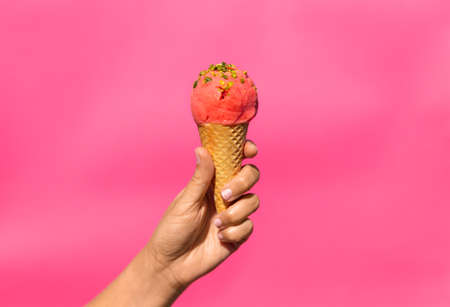 close up of hand holding waffle ice cream cone
