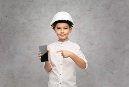 little boy in construction helmet with smartphoneの写真素材