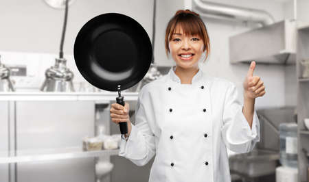 chef with frying pan showing thumbs up on kitchenの写真素材