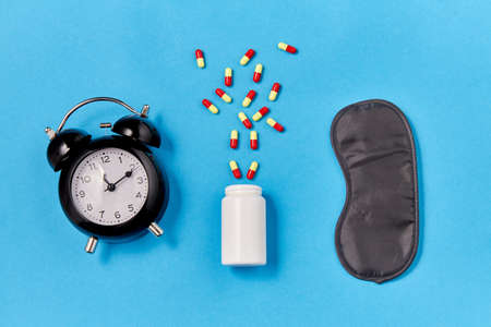 alarm clock, eye sleeping mask and pills
