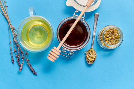 cup of herbal tea, honey and dry chamomile flowers