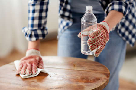 woman degreasing old table surface with solventの写真素材