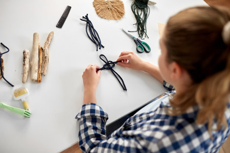 woman making macrame and knotting cords