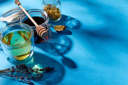cup of herbal tea, honey and dry chamomile flowers