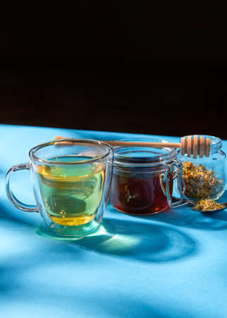 cup of herbal tea, honey and dry chamomile flowersの写真素材