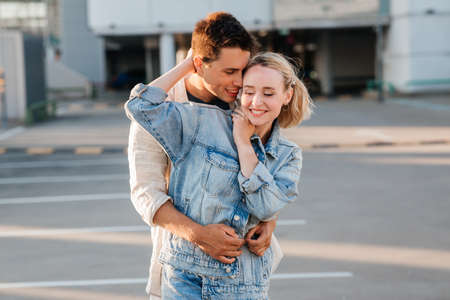 happy young couple hugging on city parkingの写真素材