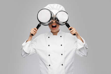 female chef with saucepans having funの写真素材