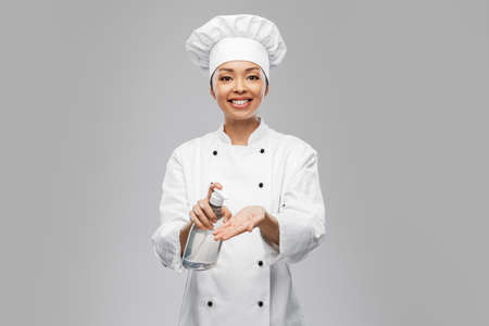 female chef applying hand sanitizer or liquid soapの写真素材