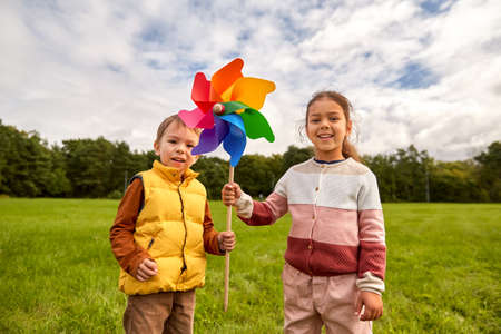 happy children playing with pinwheel at parkの写真素材