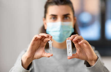 close up of woman holding self virus test