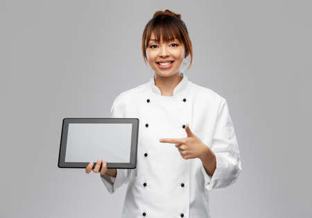 smiling female chef with tablet computerの写真素材