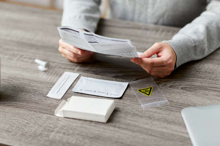 woman reading coronavirus test manual at home