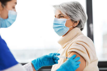 nurse with syringe making injection to womanの写真素材