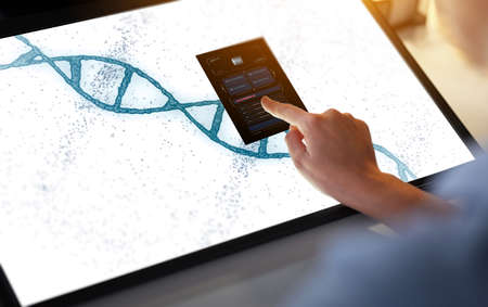 hand on led light tablet with dna moleculeの写真素材