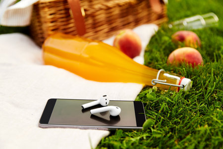 phone, earphones, picnic basket and juice bottle