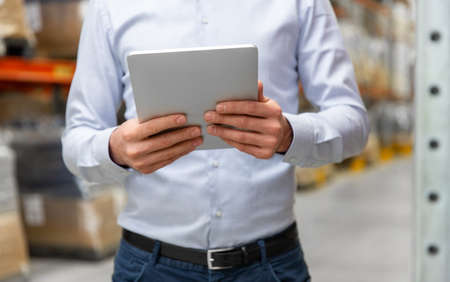 happy businessman with tablet pc at warehouseの写真素材