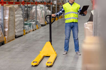 man with loader and clipboard at warehouse