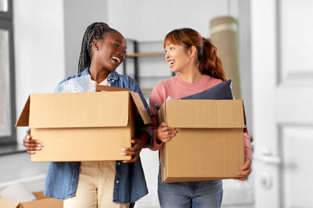 women with boxes moving to new homeの写真素材