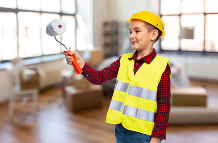 little boy in protective helmet with paint roller