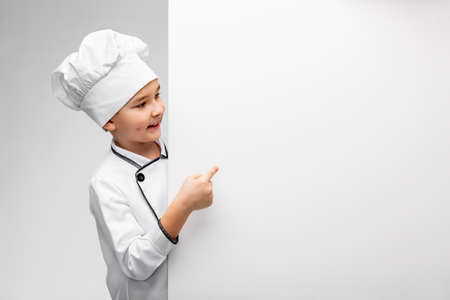 happy little boy in chefs toque with white boardの写真素材
