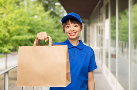 delivery woman with takeaway food in paper bagの写真素材