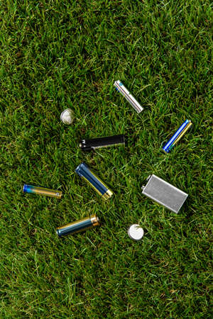 close up of alkaline batteries on grassの写真素材
