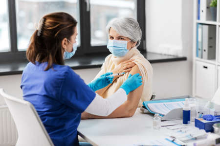 nurse with syringe making injection to womanの写真素材