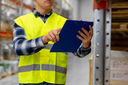 warehouse worker with clipboard in safety vestの写真素材