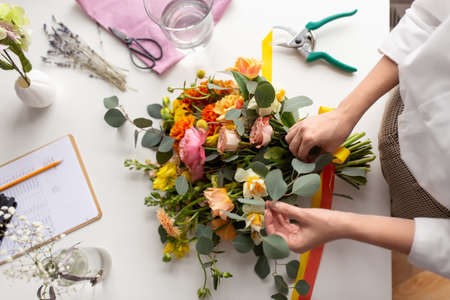 woman or floral artist making bunch of flowersの写真素材