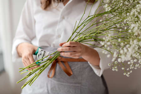 woman cutting flower stem with pruning shearsの写真素材