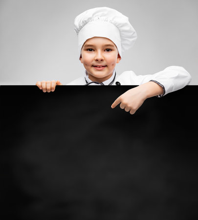 happy little boy in chefs toque with chalkboardの写真素材