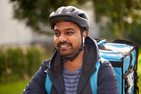 food delivery man in bicycle helmet with earphones