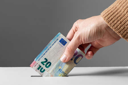 close up of hand putting money into donation boxの写真素材