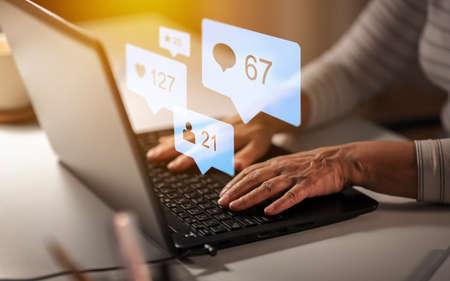 hands of old woman with laptop and internet icons