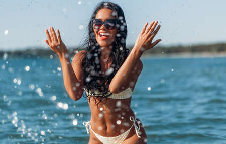 happy young woman in bikini swimsuit on beachの写真素材