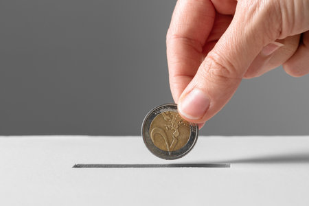 close up of hand putting coin into donation boxの写真素材